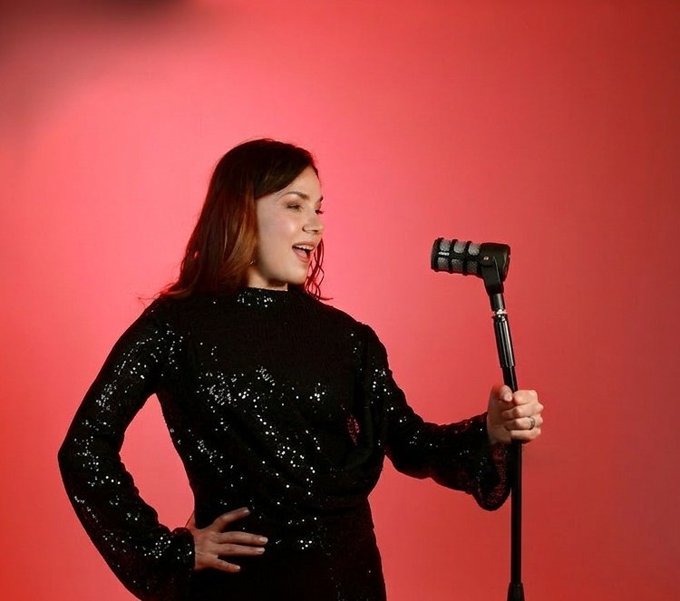 Natalia Guevara, professeure de chant à Genève, chantant au micro.